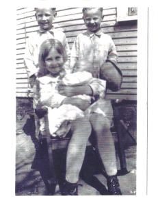 The twin boys, Albert and Delbert and my grandmother, Joy, holding her new baby sister, Bessie Marie